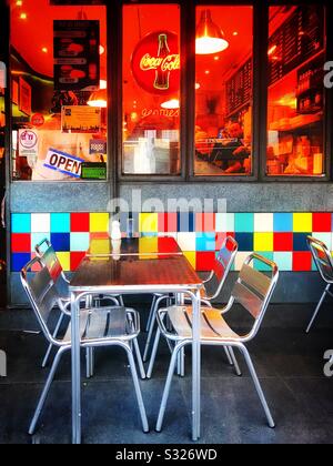 Aluminium table and chairs outside a cafe in Portobello Road , London. Colourful ceramic tiles which are on the wall under the front window, attract the attention of the passerby Stock Photo