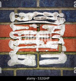 Tile cement on brick wall from where a sign once was glued Stock Photo