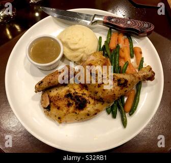 Plate of baked chicken, mashed potatoes, gravy and vegetables. Stock Photo
