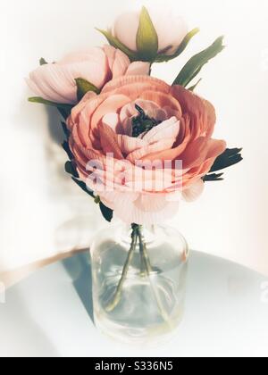Artificial silk flowers in glass vase Stock Photo