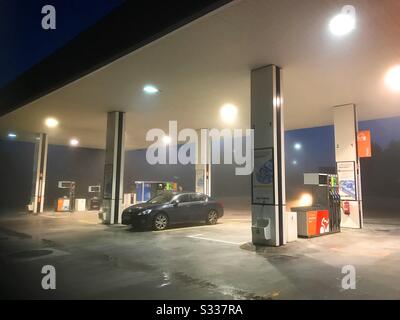 Car refuelling at gas station in the mist. Stock Photo
