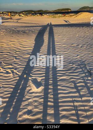 Two silhouettes in the sand. Stock Photo