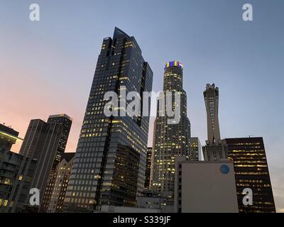 LOS ANGELES, CA, JAN 2020: Downtown skyscrapers at dusk with lights on top of US Bank Tower showing purple and yellow, LA Lakers basketball team colors in memory of player Kobe Bryant Stock Photo