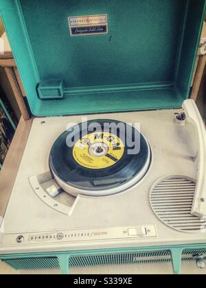 Vintage 1960s portable phonograph player and a vinyl 45 RPM record ...