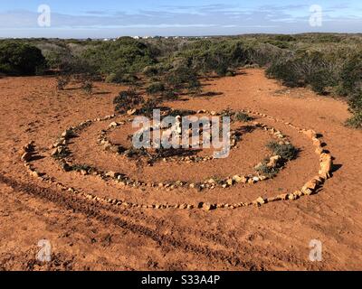 Spiral pattern made with lots of small stones placed on the ground Stock Photo