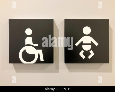 Disabled and baby change signs on a public toilet door. Stock Photo