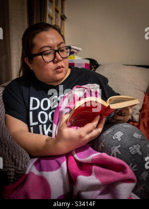 A lady relaxing reading a book. Stock Photo