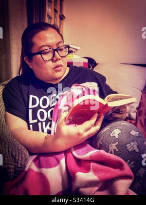 A lady relaxing reading a book. Stock Photo