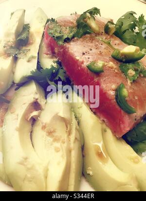 Flat lay of a gourmet entrée of seared tuna and avocados on a bed of cilantro Stock Photo