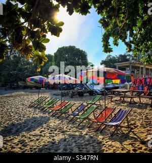 Deckchairs for tourists on the beach at Batu Ferringhi, Penang, Malaysia Stock Photo