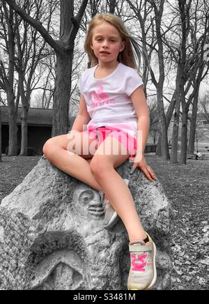 Little girl in pink on a rock Stock Photo