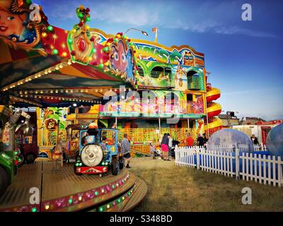 Brightly coloured fairground rides. A ride on Thomas the tank engine merry go round at an amusement park. Stock Photo