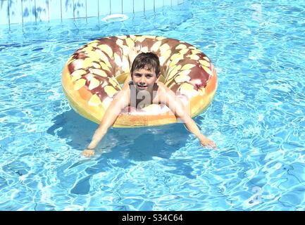 Boy in swimming pool on holiday Stock Photo