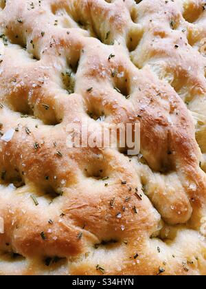 Close up of homemade focaccia bread, with rosemary and sea salt. Stock Photo