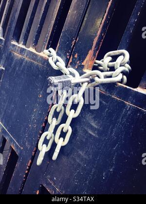 Gate locked with heavy metal chain and strong padlock Stock Photo