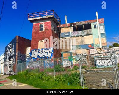 Unique boarded up building, historic wooden tankhouse and watchtower, with lots of graffiti. Oakland, California. Stock Photo