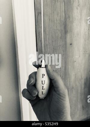 Hand on a Light Pull in Black and White Stock Photo