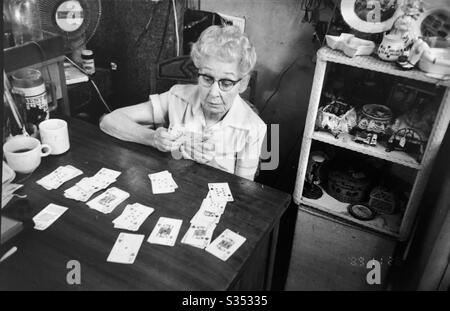 Senior woman playing solitaire sitting in her space at Texas Antique Mall Stock Photo