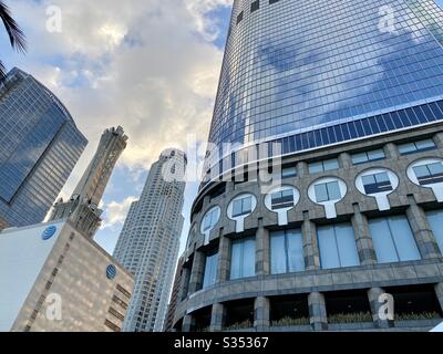 LOS ANGELES, CA, MAR 2020: US Bank Tower and nearby tall buildings viewed past bottom of skyscraper at California Plaza in Downtown on cloudy day Stock Photo