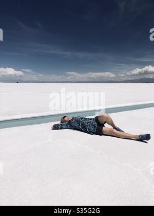 A woman relaxing on the salt flats, Salinas Grandes, in Northern Argentina. Stock Photo