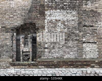 Brick wall and cobbled street in London, UK Stock Photo