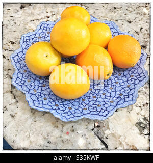 Oranges on a blue plate on table. Stock Photo