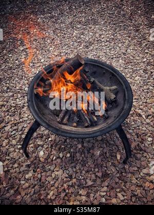Large fire in a fire pit, on gravel. Stock Photo