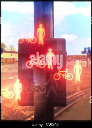 A pelican crossing for pedestrians with red man and bicycle icons duplicated outside the box, in England, UK Stock Photo