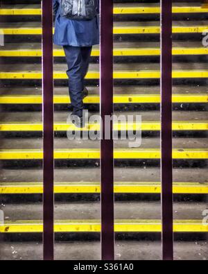 Going up - man walking up steps at railway station Stock Photo