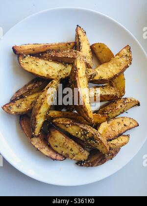 Homemade potato wedges on a white plate Stock Photo