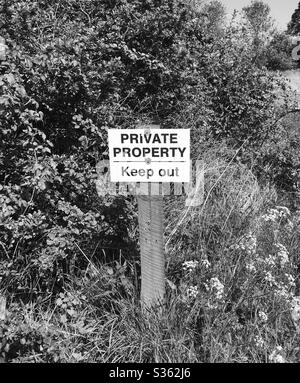 Private property sign on land with hedgerow Stock Photo