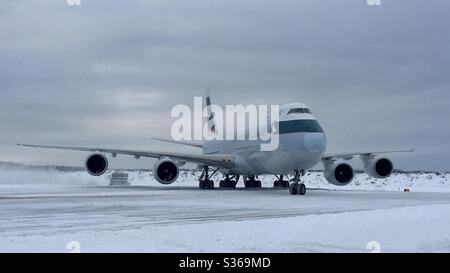 Cathay Pacific Airways Boeing 747-800 Taxying onto the ramp in Anchorage Alaska in mid winter. Stock Photo