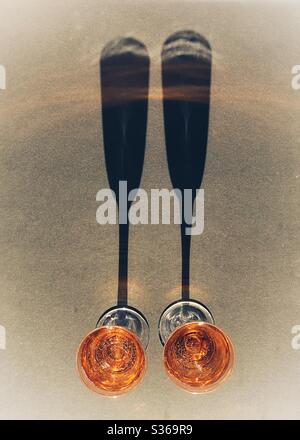 Two glasses of pink champagne with long shadows. No people. Stock Photo