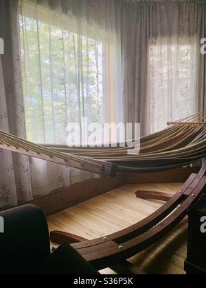 A hammock in a bay window on a sunny summer day. Stock Photo