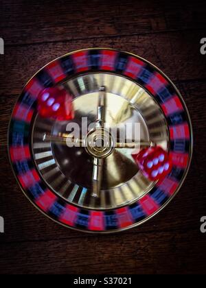 Rolling the dice, literally. Two dice showing the numbers six and three on a spinning base. Concepts: changing luck, fluidity, moving, luck of the draw, risk taking Stock Photo