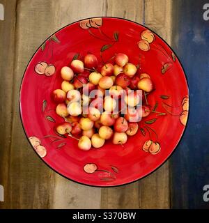 Overview of a bowl of Rainer cherries in a handpainted ceramic bowl with a Ranier cherry motif. Stock Photo