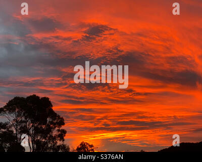 Dramatic and Glorious sunset on a winters evening with the sky looking like it’s on fire, streaked with glowing orange Stock Photo