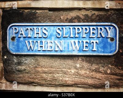 Paths slippery when wet warning sign Stock Photo