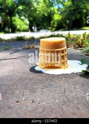 Remains of ice cream come melting on the sidewalk after being dropped Stock Photo