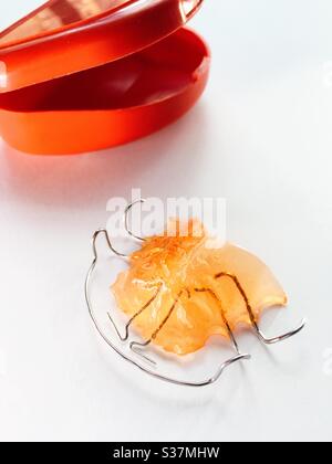 Still life of a hawley bow dental retainer appliance on a bathroom sink with a  storage case, USA Stock Photo