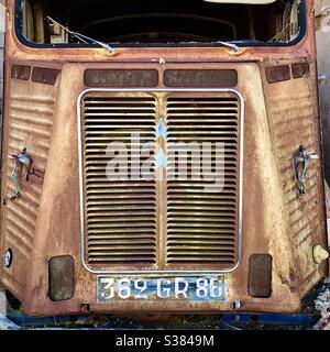 Radiator grille of rusty Citroen Type-H commercial van abandoned in French barn. Stock Photo
