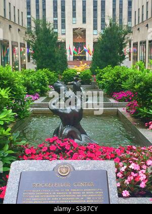 The channel Gardens in Rockefeller Center features fountains, flowers and Prometheus in the plaza in front of 30 rock sky scraper, NYC, USA Stock Photo