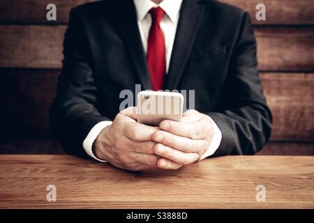 A male businessman sitting and texting on his mobile phone with copy space Stock Photo