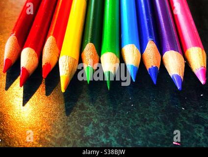 Row of fresh sharpened pencil crayons in a rainbow of colours Stock Photo