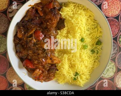 Tikka Chicken Curry with Saffron Basmati Rice with fresh garden peas Stock Photo
