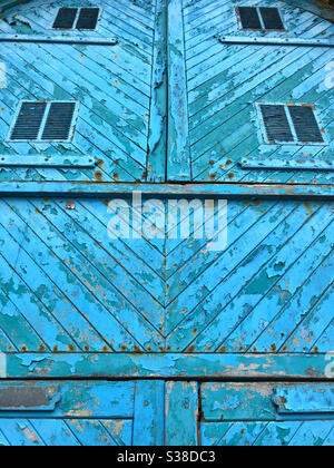 Old wooden doors with peeling blue paint. Stock Photo