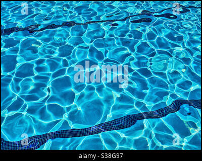 Arbitrary patterns created by bright sunlight shining on a swimming pool. A creative image that has many potential uses. Photo Credit - ©️ COLIN HOSKINS. Stock Photo