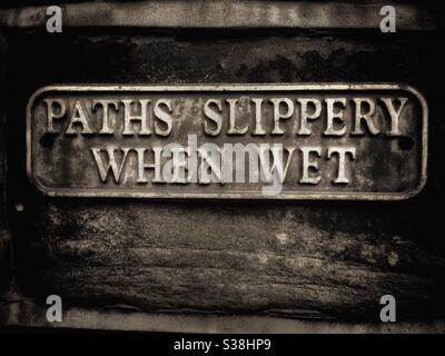 Paths slippery when wet warning sign Stock Photo