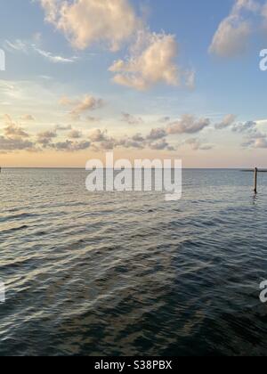 Soft sunset clouds over bay water Stock Photo - Alamy