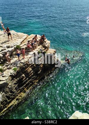 People enjoying swimming and diving from high cliffs in Adriatic Sea in Croatia, Europe Stock Photo